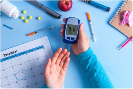 Person holding a blood glucose monitor showing their result.